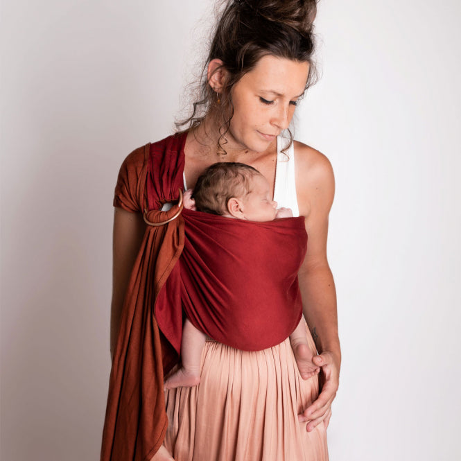 Mama mit Kind in Tragetuch Sling